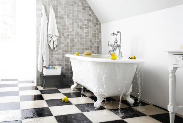 Bright bathroom. the water runs over the bathtub down to the floor. water damage to the floor